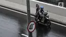 Pengendara sepeda motor menerobos Jalan Layang Non Tol (JLNT) Casablanca saat hujan, Jakarta, Minggu (20/12/2020). Aksi nekat pengendara sepeda motor tersebut dapat mengancam keselamatan diri serta pengguna jalan lain. (merdeka.com/Iqbal S. Nugroho)