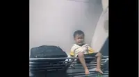 Bocah tampak duduk menangis di bagasi kereta