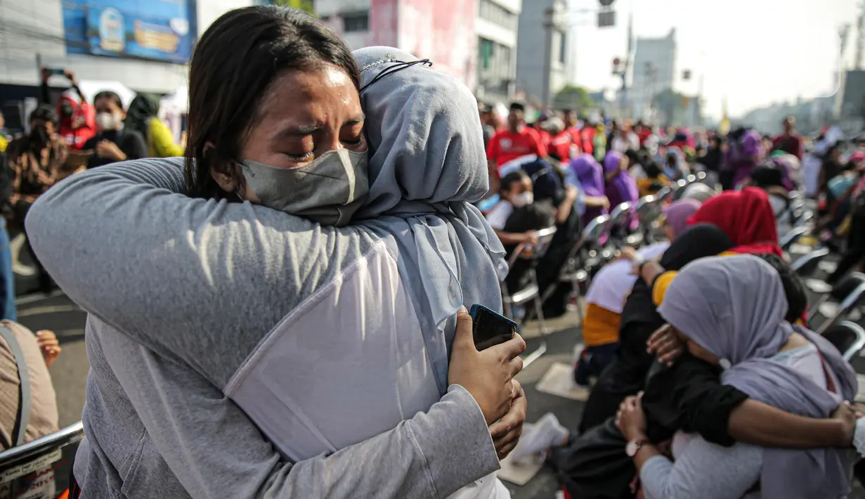 Sejumlah anak memeluk ibunya pada aksi cuci kaki ibu massal di Jakarta, Minggu (18/12/2022). Aksi yang diikuti sebanyak ratusann peserta itu bertujuan untuk meningkatkan rasa cinta kasih kepada ibu , khususnya dalam rangka memperingati Hari Ibu. (Liputan6.com/Faizal Fanani)