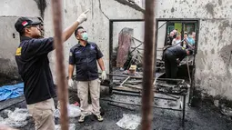 Tim penyelidik bekerja di lokasi kebakaran pabrik korek gas di Binjai, Langkat, Sumatera Utara, (21/6/2019). Kebakaran terjadi terjadi sekitar pukul 12.00 WIB diawali suara ledakan dari sekitar lokasi kejadian. (Ivan Damanik/AFP)