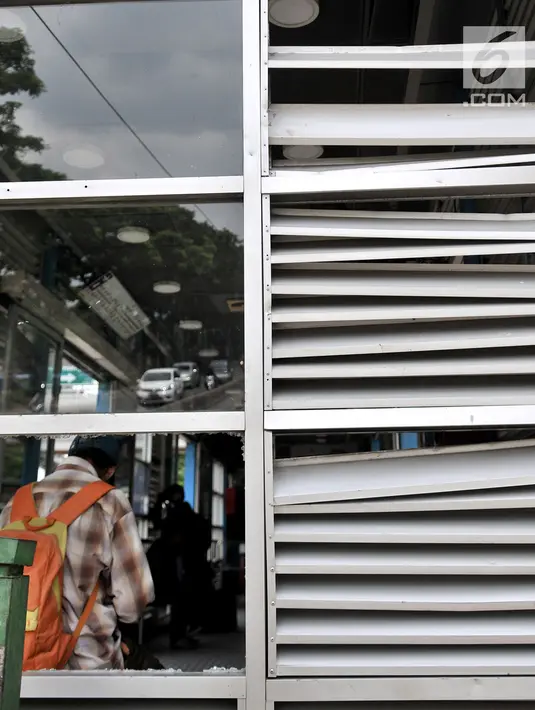 Penumpang menunggu bus di Halte Transjakarta Pasar Rumput, Manggarai, Jakarta, Minggu (3/2). Tawuran antarwarga menyebabkan Halte Transjakarta Pasar Rumput rusak akibat terkena lemparan batu. (Merdeka.com/Iqbal Nugroho)