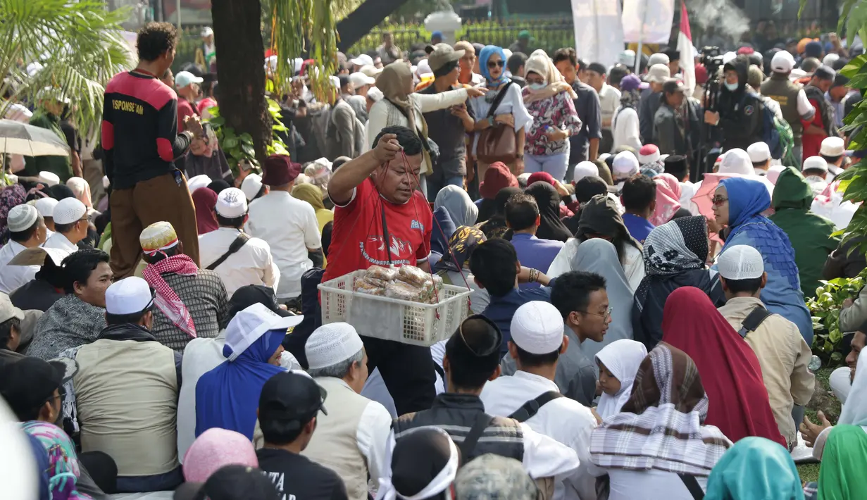 Pedagang asongan menawarkan dagangannya di sela-sela massa aksi di sekitaran Jalan Medan Merdeka Barat, Jakarta, Kamis (27/6/2019). Massa yang melakukan aksi terkait sidang putusan perselisihan hasil Pilpres 2019 memberi keuntungan bagi para pedagang. (Liputan6.com/Helmi Fithriansyah)