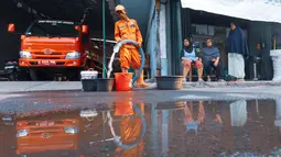 Petugas mengisi wadah milik warga saat pendistribusian air bersih oleh BPBD DKI Jakarta di Cilandak Timur, Jakarta Selatan, Senin (21/9/2026). Penyaluran dilakukan untuk membantu warga memenuhi kebutuhan air selama kekeringan berlangsung. (KLY/Budy Santoso)
