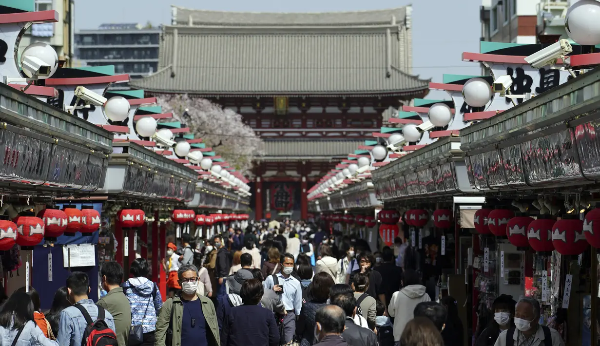 Orang-orang yang mengenakan masker pelindung untuk membantu mengekang penyebaran virus corona melalui arena perbelanjaan di distrik Asakusa di Tokyo, Rabu (31/3/2021).  Ibukota Jepang mengonfirmasi lebih dari 410 kasus virus corona baru pada hari Rabu. (AP Photo/Eugene Hoshiko)
