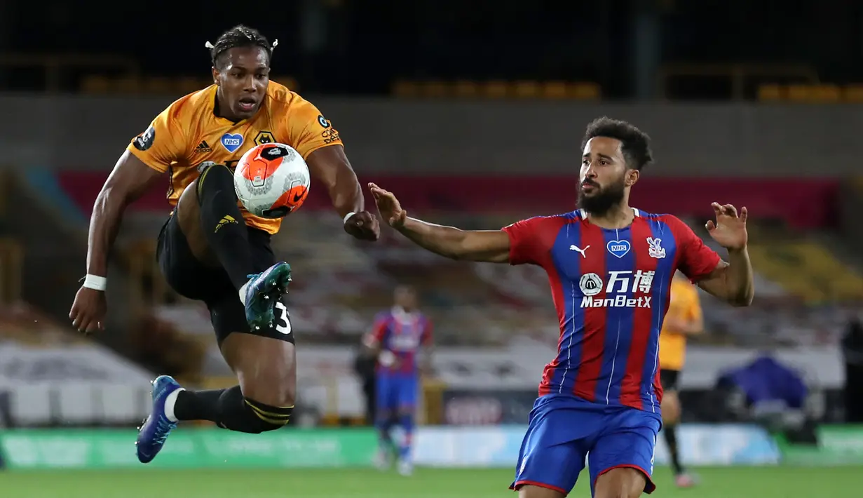 Gelandang Wolverhampton Wanderers, Adama Traore, berebut bola dengan gelandang Crystal Palace, Andros Townsend, pada laga lanjutan Premier League di Molineux Stadium, Selasa (21/7/2020) dini hari WIB. Wolves menang 2-0 atas Crystal Palace. (AFP/Martin Rickett/pool)