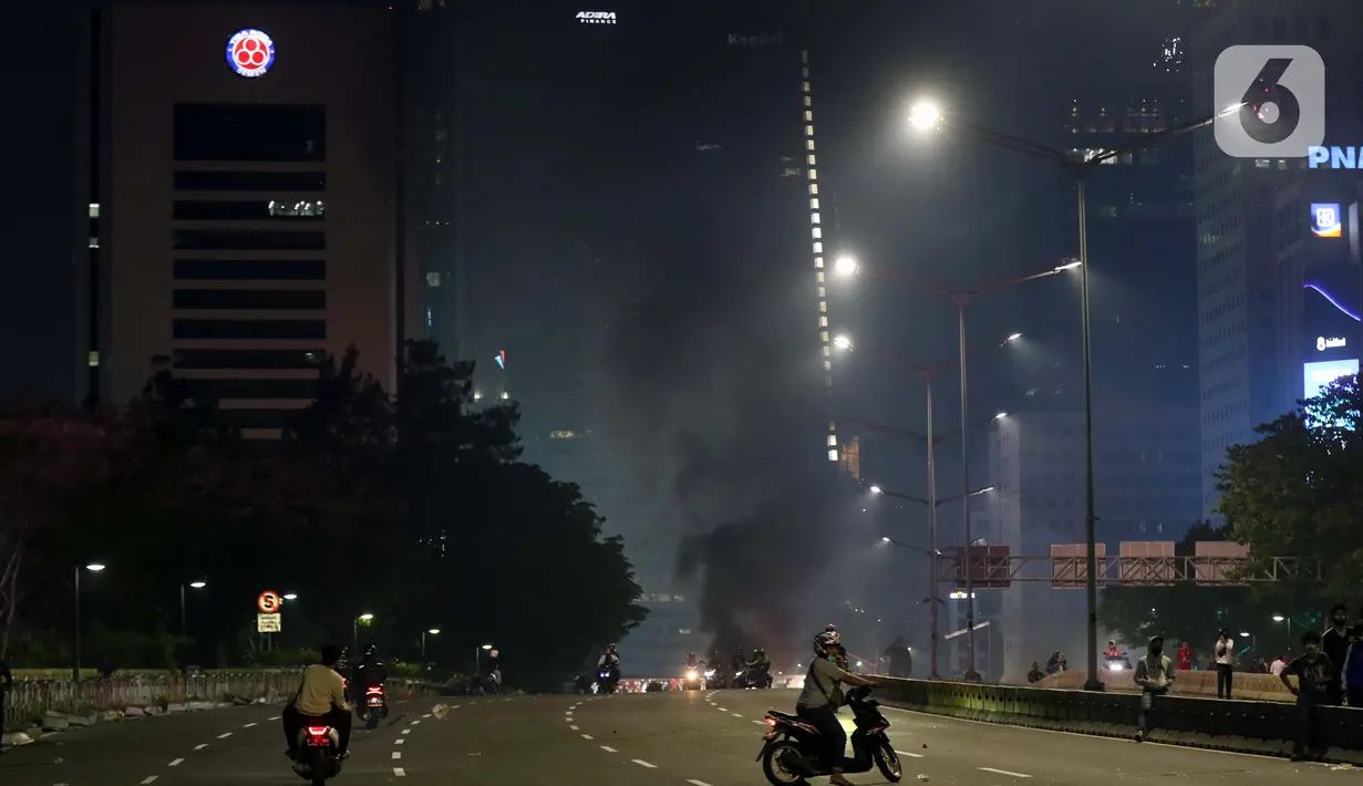 Asap hitam pembakaran membumbung di Jalan Jenderal Sudirman, Jakarta, Kamis (8/10/2020). Unjuk rasa menentang disahkannya Omnibus Law UU Cipta Kerja berujung aksi anarkis merusak berbagai fasilitas umum. (Liputan6.com/Helmi Fithriansyah)