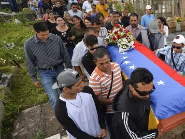 Keluarga dan kerabat mengantarkan jenazah Jose Francisco Guerrero untuk dimakamkan di San Cristobal, Tachira State, Venezuela (19/5). Jose Francisco Guerrero adalah remaja 15 tahun yang tewas ditembak saat kerusuhan di Venezuela. (AFP/Luis Robayo)