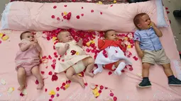 Bayi-bayi ditaburi kelopak mawar sambil terlentang di atas matras untuk dilompati selama festival El Colacho di desa Castrillo de Murcia, bagian utara Spanyol, 23 Juni 2019. Festival melompati bayi ini bermakna untuk membersihkan bayi berusia hingga satu tahun dari roh-roh jahat. (CESAR MANSO/AFP)