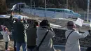 Warga saat menyambut dengan meriah kereta peluru Shinkansen tujuan Shin-hakodate-Hokuto di stasiun Tokyo, Sabtu (26/3). Warga Jepang bersuka cita karena diresmikannya jalur kereta peluru Shinkansen menuju pulau utara Hokkaido. (JIJI PRESS / AFP)