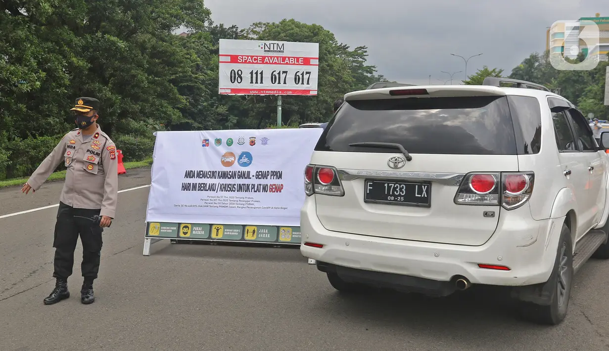 Polisi berjaga saat pemberlakuan aturan ganjil-genap di pos sekat Gerbang Tol Bogor, Kota Bogor, Sabtu (6/2/2021). Aturan ganjil-genap di setiap akhir pekan di wilayah Kota Bogor itu untuk mengurangi mobilitas warga di tengah meningkatnya kasus positif COVID-19. (Liputan6.com/Herman Zakharia)
