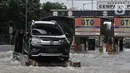 Sebuah mobil mogok diderek akibat nekat menerobos banjir di Tol Cempaka Putih, Jakarta, Minggu (23/2/2020). Banjir yang melanda kawasan tersebut menyebabkan Gerbang Tol Cempaka Putih tidak dioperasikan akibat terendam hingga ketinggian mencapai sepinggang orang dewasa. (merdeka.com/Iqbal S. Nugroho)