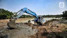 Petugas Sudin SDA Jakarta Timur menggunakan alat berat untuk mengeruk lumpur di Waduk Setu, Cipayung, Jakarta, Rabu (28/7/2021). Pengerukan lumpur ini dilakukan untuk mencegah terjadinya banjir saat musim hujan. (merdeka.com/Iqbal S. Nugroho)