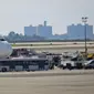 Petugas tanggap darurat berkumpul di luar pesawat setelah penumpang Emirates Airline dilaporkan jatuh sakit di Bandara Kennedy New York, Rabu (5/9). Sekitar 100 dari total 500 penumpang pesawat dari Dubai itu mengeluh sakit dan demam. (AP/Bebeto Matthews)