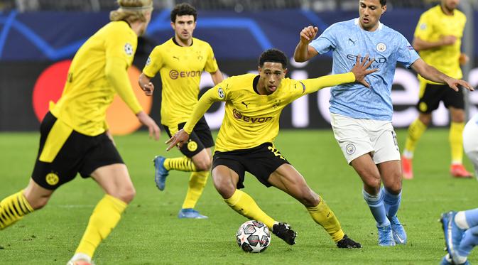 Gelandang Borrusia Dortmund, Jude Bellingham membawa bola dari kawalan gelandang Manchester City, Rodrigo pada pertandingan leg kedua perempat final Liga Champions di stadion Signal Iduna Park, Jerman (15/4/2021). The Citizens unggul agregat 4-2 atas Dortmund. (AP Photo/Martin Meissner)