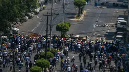 Pengunjuk rasa mendirikan barikade untuk memblokir polisi saat menentang kudeta militer di Yangon (28/2/2021). Polisi melepaskan tembakan di berbagai bagian kota terbesar Yangon setelah granat kejut, gas air mata, dan tembakan ke udara gagal memecah kerumunan. (AFP/ Ye Aung Thu)