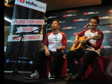 Pemenang ketiga dan kedua Music Video Contest, Eros Tjokro  (kiri) dan Dibya Dika (kanan) saat berduet di kantor Vidio.com, SCTV Tower, Jakarta, Rabu (28/1/2015). (Liputan6.com/Herman Zakharia)