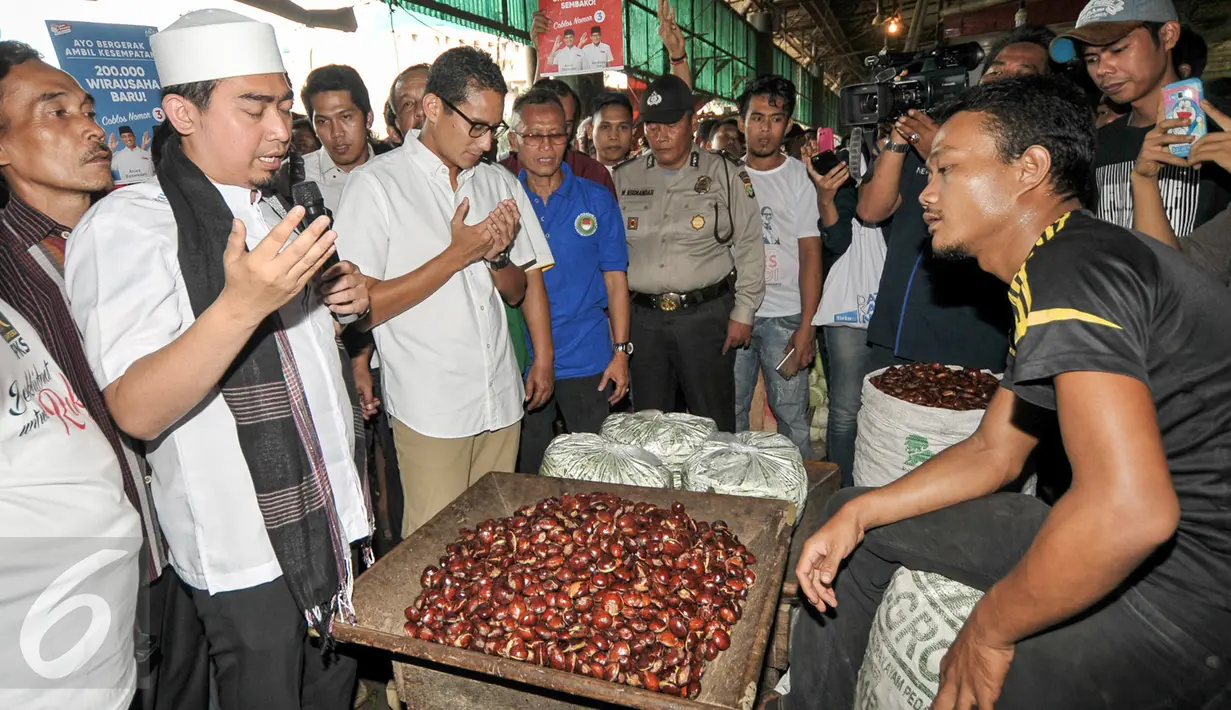 Ustad Solmed mendoakan pedagang di Pasar Induk, Kramat Jati saat menemani Cawagub DKI Jakarta, Sandiaga Uno blusukan, Jakarta, Senin (16/1). (Liputan6.com/Yoppy Renato)
