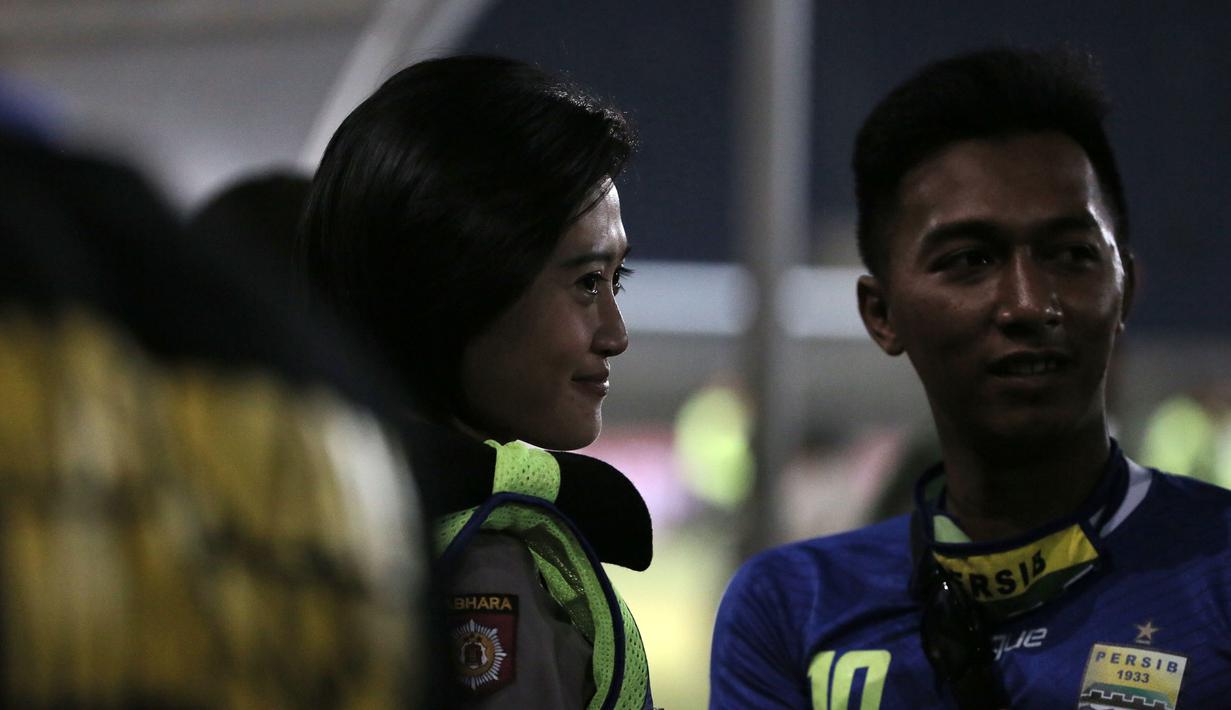 Seorang Polwan berfoto bersama suporter di Stadion Si Jalak Harupat, Bandung, Minggu (25/10/2015). (Bola.com / Nicklas Hanoatubun)