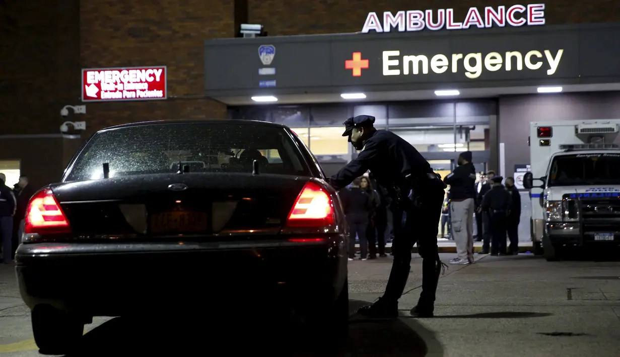 Petugas kepolisian berkumpul di pintu masuk darurat Rumah Sakit Lincoln setelah dua polisi New York ditembak di Bronx, Kamis (4/2). Dua orang polisi ditembak saat tengah melakukan patroli malam di komplek perumahan di Bronx. (REUTERS/Andrew Kelly)