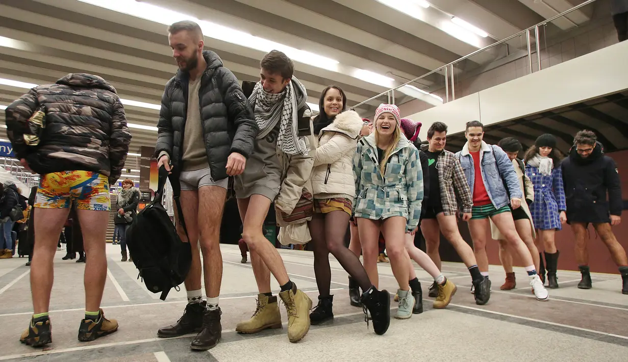 Penumpang mengantre naik kereta tanpa mengenakan celana selama berpartisipasi dalam 'No Pants Subway Ride' di Polandia (8/1). Acara tahunan ini digelar di berbagai negara khususnya naik kereta tanpa memakai celana. (AP Photo/Czarek Sokolowski)