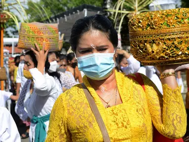 Umat Hindu membawa sesaji saat akan berdoa pada perayaan Hari Raya Kuningan di Pura Sakenan, Pulau Serangan, Denpasar, Bali, Sabtu (20/11/2021). Kuningan merupakan hari terakhir perayaan Galungan yang diyakini sebagai hari naiknya roh suci leluhur kembali ke surga. (Sonny TUMBELAKA/AFP)