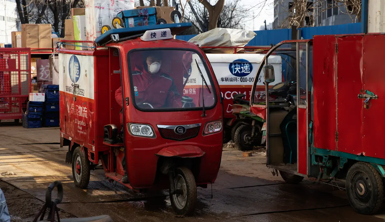 Kurir membawa paket yang akan dikirimkan ke palanggan dari pusat distribusi di Beijing, China, Selasa (18/2/2020). Hingga 19 Februari 2020, sebanyak 1.779 pasien telah diizinkan meninggalkan rumah sakit usai dinyatakan sembuh dari virus corona atau COVID-19 di China. (AP Photo/Ng Han Guan)