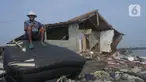 Carmad (80) membuat penahan ombak dari bambu di Kampung Pisangan Desa Cemara Jaya, Kabupaten Karawang, Jawa Barat, Rabu (24/4/2024). (merdeka.com/Imam Buhori)