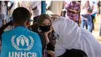 Aktris Angelina Jolie, utusan khusus badan PBB untuk urusan pengungsi (UNHCR), berbincang-bincang dengan Pengungsi Mali di Kamp Goudebo, di utara Burkina Faso, dalam peringatan Hari Pengungsi Sedunia, Minggu, 20 Juni 2021. (Olympia de Maismont/AFP)