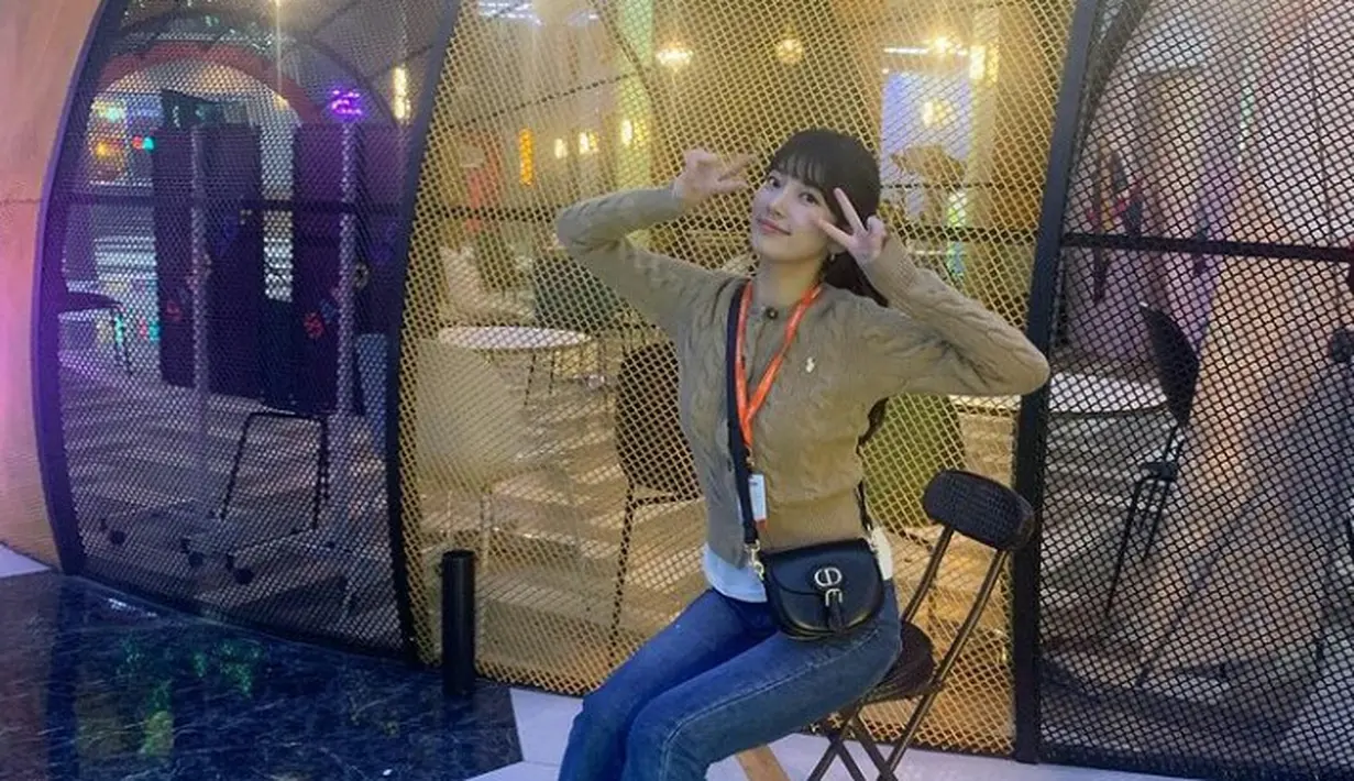 Kali ini, Suzy tampil dengan gaya smart casual dengan padu padan kardigan, kemeja sebagai inner, dan celana jeans. Penampilannya diperlengkap dengan celana jeans dan flat shoes. (Instagram/skuukzky).