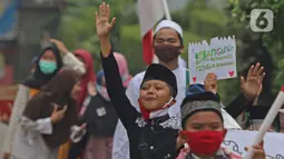 Sejumlah anak pengajian melakukan pawai di Jalan Raya Tapos, Depok, Jawa Barat, Kamis (22/10/2020). Pengajian Kampung Tapos menggelar pawai menyambut Hari Santri Nasional 2020 yang diperingati setiap tanggal 22 Oktober. (Liputan6.com/Herman Zakharia)