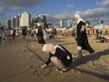 Warga Palestina menikmati hari di pantai saat perayaan Idul Adha, di Tel Aviv, Israel, Kamis, 29 Juni 2023. (AP Photo/Oded Balilty)