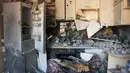 Puing-puing menutupi dapur yang rusak di sebuah gedung apartemen yang terkena tembakan di Kharkiv, Ukraina, 20 Maret 2022. Pada Hari 25 perang Rusia di Ukraina, kehidupan yang kacau, perpisahan yang pahit tertangkap dalam foto-foto Associated Press. (AP Photo/Andrew Marienko)