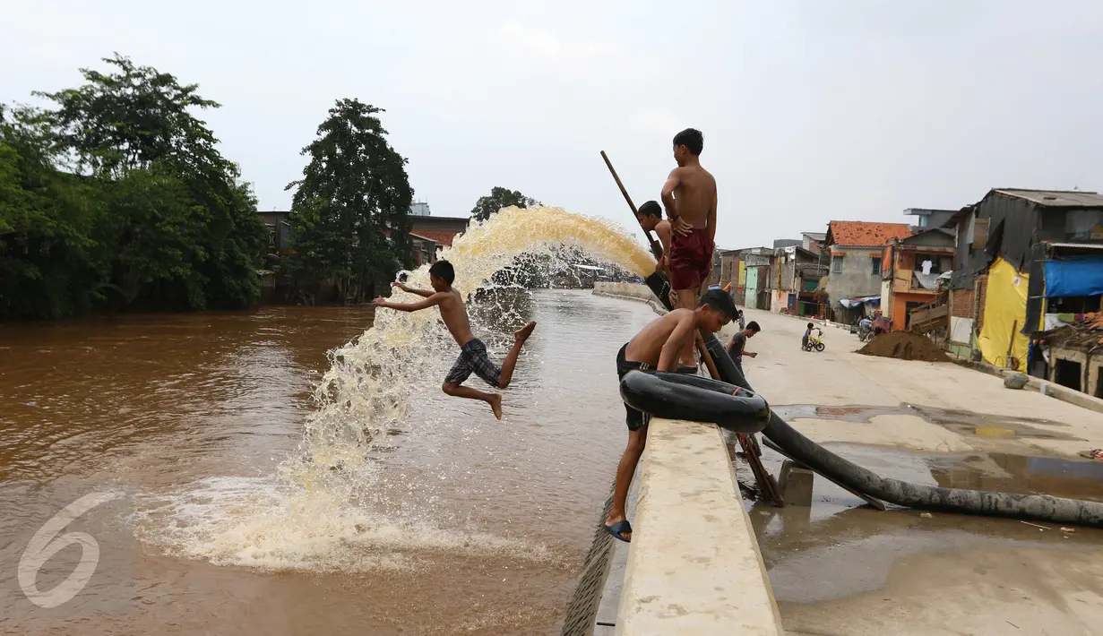 Anak - anak berlompat di kali Ciliwung, Kampung Pulo, Jakarta Timur, Sabtu (12/3). Kurangnya lahan bermain membuat mereka terpaksa bermain di bantaran kali Ciliwung. (Liputan6.com/Gempur M Surya)