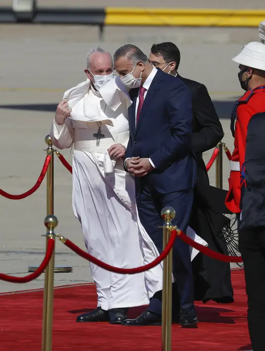 Paus Fransiskus disambut oleh PM Irak Mustafa al-Kadhimi saat tiba di Bandara Internasional Baghdad, Irak, Jumat (5/3/2021). Paus Fransiskus datang ke Irak untuk mendesak umat Kristen tetap tinggal dan membantu membangun kembali Irak setelah bertahun-tahun perang. (AP Photo/Andrew Medichini)