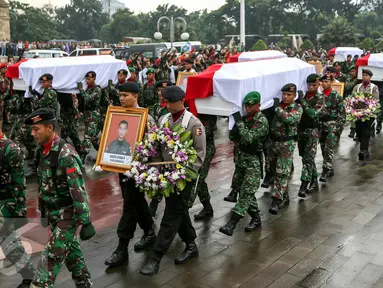 Sebanyak 13 jenazah korban jatuhnya helikopter di Poso dimakamkan TMP Kalibata, Jakarta, Selasa (22/3). Sebelumnya dilangsungkan upacara pelepasan jenazah yang dipimpin oleh Presiden Jokowi di Lanud Halim Perdana Kusuma. (Liputan6.com/Yoppy Renato)