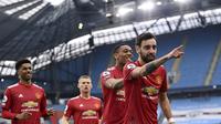 Gelandang Manchester United atau MU Bruno Fernandes dan rekan-rekannya merayakan gol ke gawang Manchester City dalam lanjutan Liga Inggris di Etihad Stadium, Minggu (7/3/2021). (Laurence Griffiths/Pool via AP)
