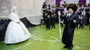 Pengantin Yahudi ultra-ortodoks Hannah Halbershtam memasuki bagian pria saat melangsungkan upacara pernikahan di kota ultra-ortodoks Bnei Brak, Israel, Selasa (20/8/2019. Dalam acara ini keluarga dan para rabi terhormat diundang untuk menari di depan pengantin wanita. (AP Photo/Oded Balilty)