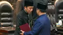 Presiden Republik Indonesia Prabowo Subianto (kanan) menyapa pendahulunya Joko Widodo (L) saat upacara pelantikan presiden di gedung Parlemen di Jakarta pada tanggal 20 Oktober 2024. (BAY ISMOYO/AFP)