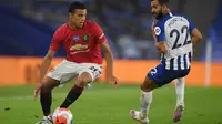 Striker Manchester United, Mason Greenwood, berebut bola dengan pemain Brighton pada laga Premier League pekan ke-32 di Stadion Falmer, Rabu (1/7/2020) dini hari WIB. Manchester United menang 3-0 atas Brighton. (AFP/Mike Hewitt/pool)