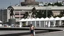 Seorang pria berjalan di sepanjang tepi pantai Thessaloniki, Yunani utara (23/6/2021).  Yunani bersiap menghadapi gelombang panas pertama musim panas, mendorong suhu siang hari ke wilayah 40+ Celcius di banyak bagian negara. (AFP/ Sakis Mitrolidis)