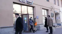 Orang-orang antre menarik uang dari ATM Bank VTB di pusat kota Moskow, 28 Februari 2022. Anjloknya nilai mata uang Rusia, rubel, dalam perdagangan menyusul sanksi terkait invasi di Ukraina membuat warga ramai-ramai mendatangi ATM hingga bank untuk menarik uang tunai mereka. (AP Photo/Pavel Golovkin)