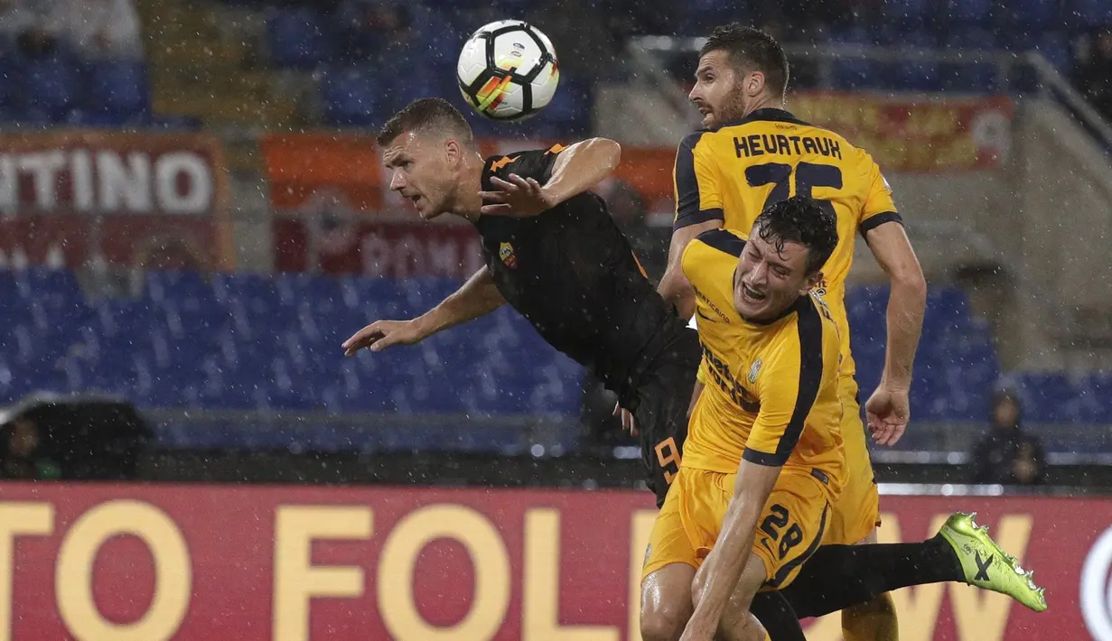 Pemain AS Roma, Edin Dzeko (kiri) melakukan duel dengan pemain Hellas Verona, Alex Ferrari dan Thomas Heurtaux pada lanjutan Serie A di Olympic stadium, Roma, (16/9/2017). Roma menang 3-0. (AP/Andrew Medichini)