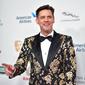 Aktor komedi Jim Carrey berpose saat tiba menghadiri acara BAFTA Los Angeles Britannia Awards 2018 di Beverly Hilton di Beverly Hills, California (26/10). Jim Carrey tampil keren mengenakan jas bermotif kembang. (AFP Photo/Neilson Barnard)