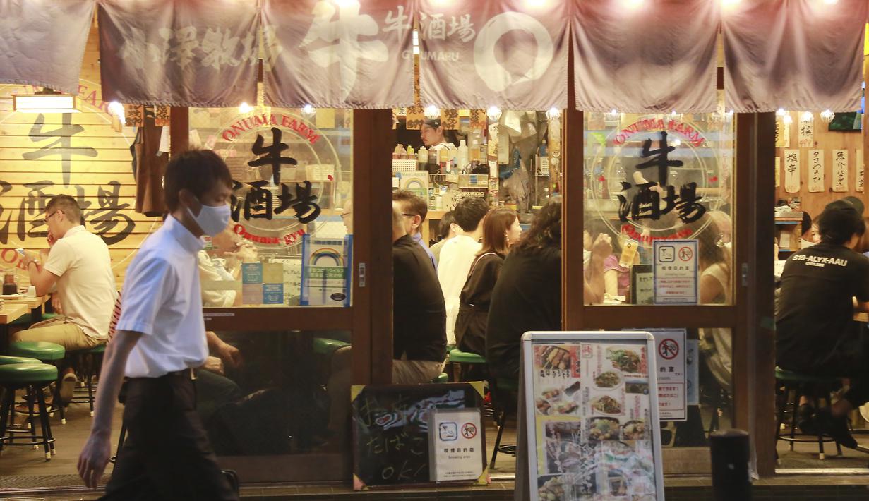 Orang-orang minum di bar selama keadaan darurat COVID-19 di Tokyo, Jepang pada Senin (12/7/2021). Status darurat keempat di Tokyo ini, yang berlaku hingga 22 Agustus, akan mencakup durasi gelaran Olimpiade Tokyo. (AP Photo/Koji Sasahara)