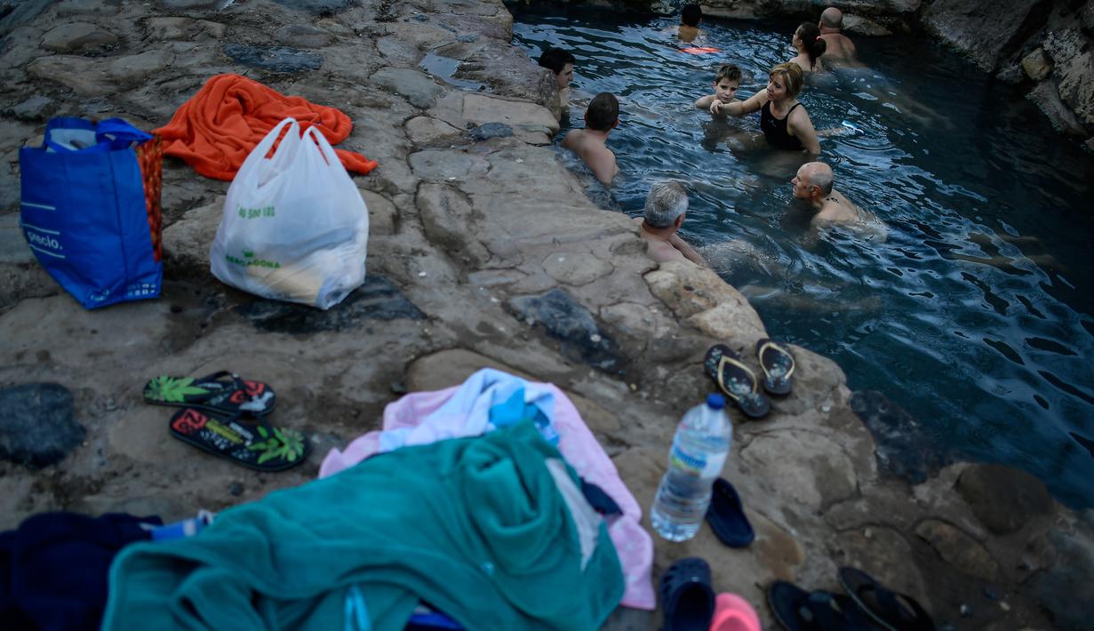 Pengunjung menikmati pemandian air panas alami Sungai Cidaco dengan suhu 52 Celcius saat pagi musim dingin di desa kecil Arnedillo, Spanyol utara, 29 Desember 2018. (AP Photo/Alvaro Barrientos)