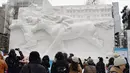 Sejumlah pengunjung melihat patung es balap kuda selama hari pembukaan Festival Salju Sapporo di Sapporo, Jepang (4/2). Festival salju Sapporo pertama kali diselengarakan tahun 1950. (AFP Photo/Jiji Press)
