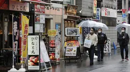Warga memakai masker untuk melindungi dari penyebaran virus corona berjalan di jalan yang dipenuhi bar dan restoran di Tokyo (8/3/2021). Pemerintah Jepang memperpanjang keadaan darurat di wilayah Tokyo hingga 21 Maret karena sistem medis masih disaring oleh pasien COVID-19. (AP Photo/Koji Sasahara)