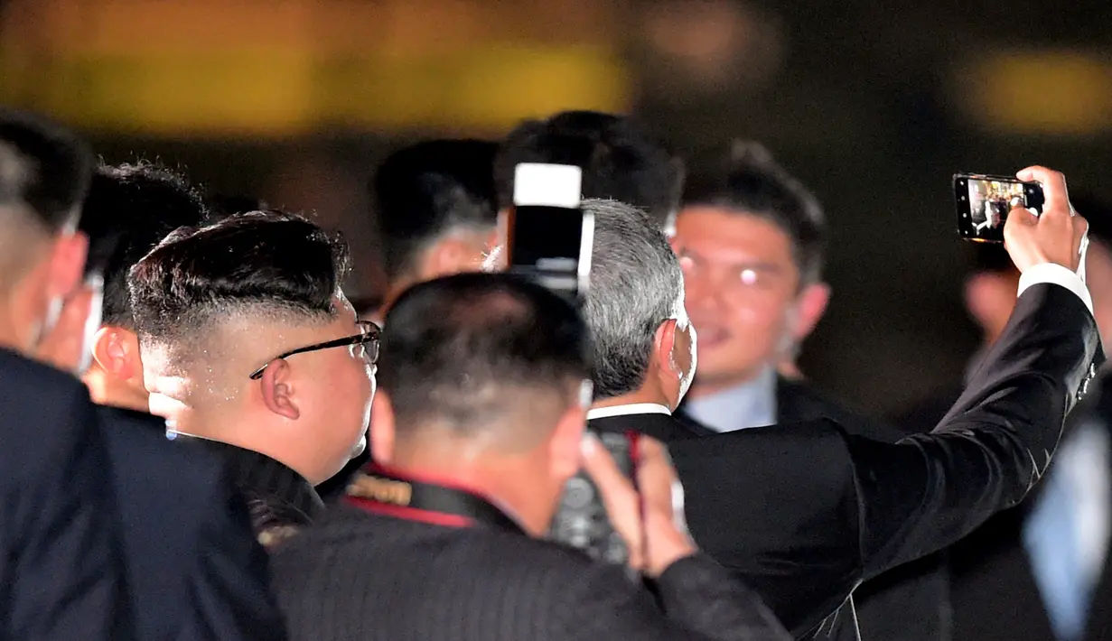 Pemimpin Korea Utara Kim Jong-un berswafoto dengan Menteri Luar Negeri Singapura, Vivian Balakrishnan Balakrishnan saat mengunjungi Gardens by the Bay, Senin (11/6). Kim terlihat santai menjelang pertemuannya dengan Donald Trump. (AP Photo/Joseph Nair)