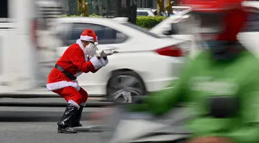 Petugas lalu lintas, Ramiro Hinojas mengenakan kostum sinterklas sambil mengarahkan kendaraan di sepanjang Macapagal Avenue di Pasay, Metro Manila, Filipina pada 28 November 2023. (JAM STA ROSA/AFP)