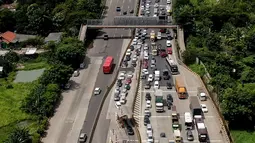 Foto aerial kendaraan terjebak macet di Pintu Tol Cikupa, Tangerang, Banten, Kamis (28/4/2022). Memasuki H-4 Hari Raya Idulfitri 1443 H atau Lebaran 2022, kendaraan pemudik dengan menggunakan kendaraan pribadi mengular di pintu tol Cikupa arah Merak. Kemacetan terjadi kurang lebih hingga dua km meter. (Liputan6.com/Angga Yuniar)